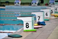 Diving blocks and kickboards next to a swimming pool