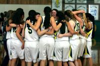A women's sports team in a huddle.